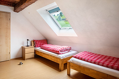 Schlafzimmer mit Doppelbett und zwei Einzelbetten