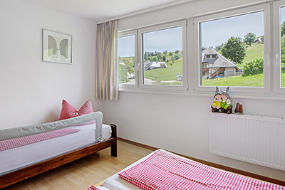 Schlafzimmer mit Doppelbett und Kinderbett