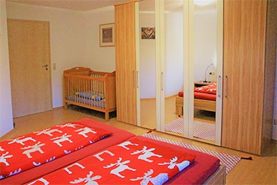 Schlafzimmer mit Doppelbett und Kinderbett
